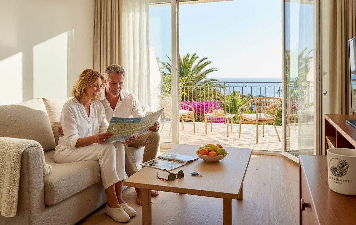 Pärchen genießt den sonnigen Ausblick vom Balkon ihrer Ferienwohnung auf Teneriffa.